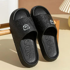 Black slide sandals with bear graphic and textured footbed, open toe
