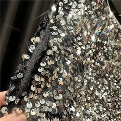 Silver-tone sequined shorts close-up with dense round sequins and glittery finish