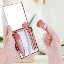Travel makeup brush set in open case with mirror, holding pink bristle brushes