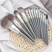 14-piece makeup brush set with silver handles and gray bristles on braid mat