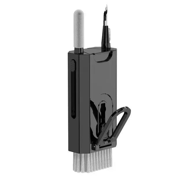 Black device cleaning tool with vertical brush, swab accessory slot, and key puller