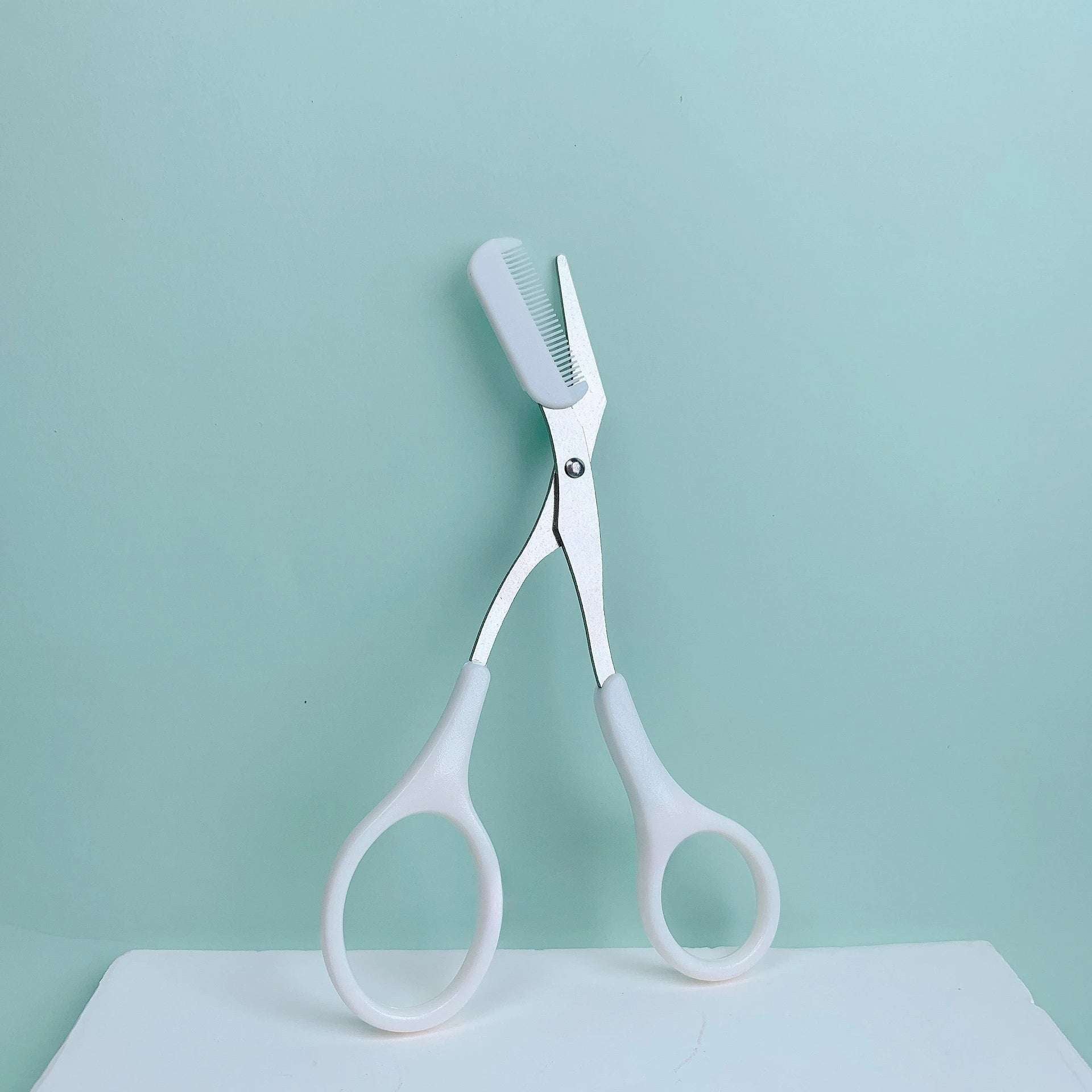 Pink eyebrow trimming scissors with built-in comb - stainless steel, precise grooming tool, creating perfect eyebrows