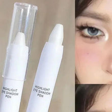Highlight eyeshadow pen with clear cap shown beside eye makeup application