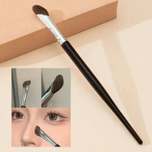 Angled makeup brush with brown bristles on a silver ferrule and a black handle