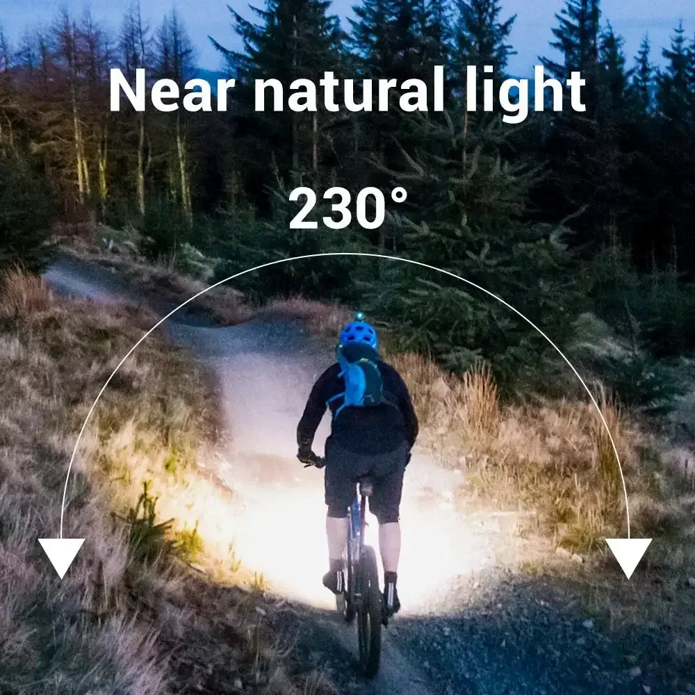Headlamp on a cyclist projecting a wide bright beam down a path