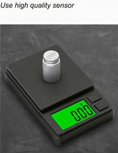 Digital pocket scale with container on platform and green backlit LCD reading 0.000