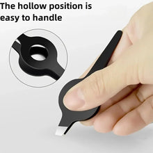 Black eyebrow tweezers with hollow grip handle, close-up with finger