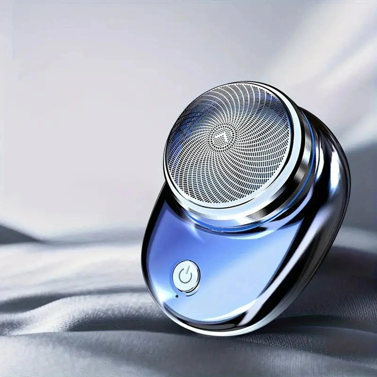 Blue electric shaver with circular foil head and power button on fabric