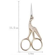 Silver-tone eyebrow and nose hair scissors with ornate handle, round finger loops.