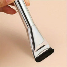 Close-up of foundation brush tip with black bristles and silver metal handle