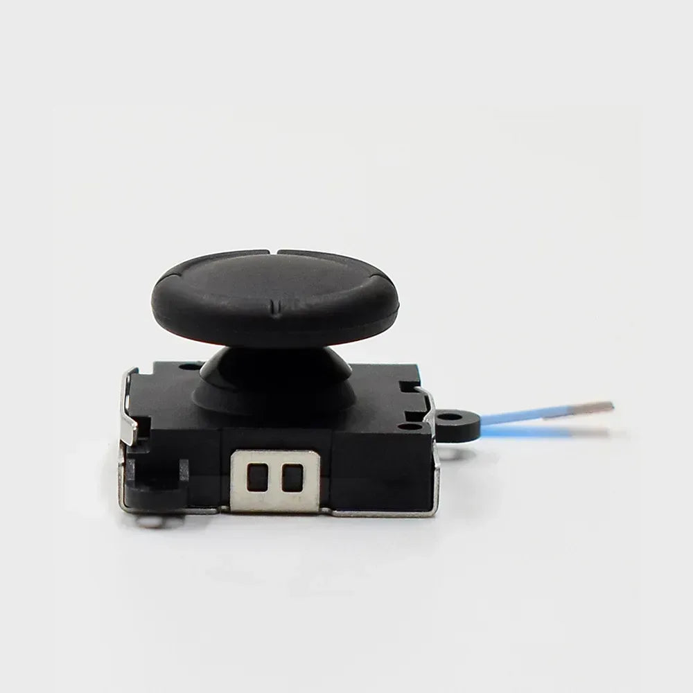 Analog joystick replacement module with black cap and blue ribbon cable, close-up