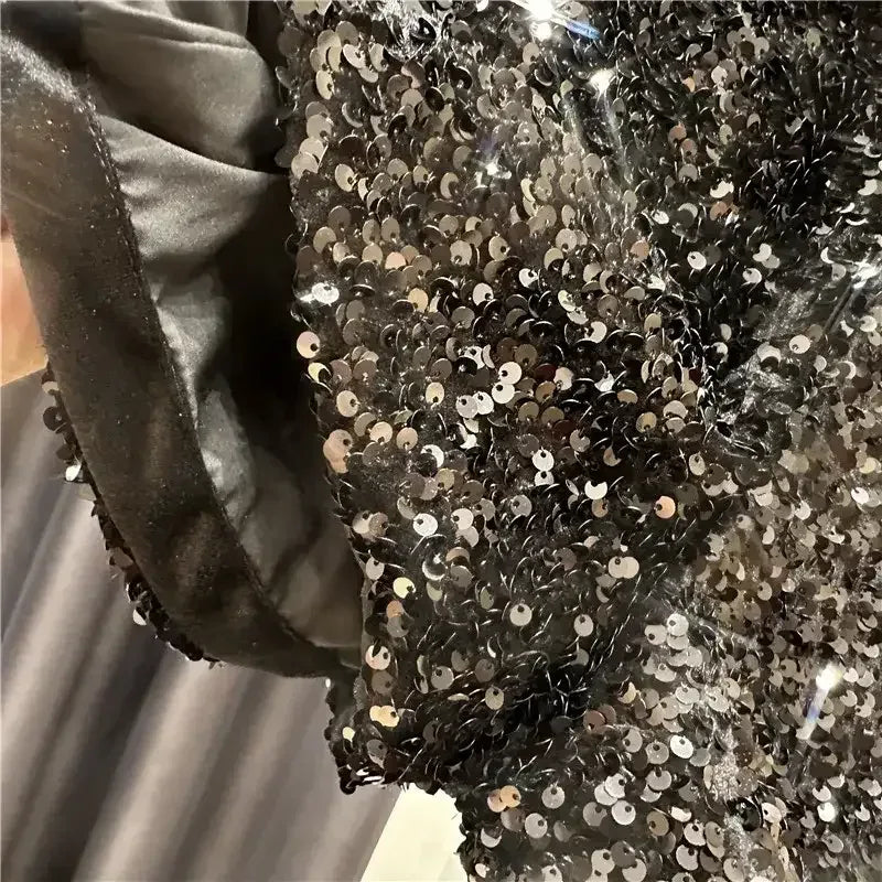 Silver sequins over dark underlay on shorts, close-up of shimmering fabric