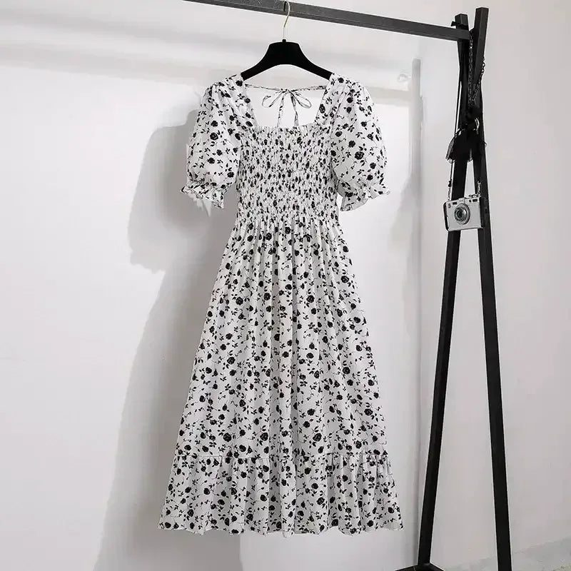 White with black floral A-line dress with smocked bodice, short puff sleeves, and elastic waist