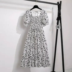 White with black floral A-line dress with smocked bodice, short puff sleeves, and elastic waist