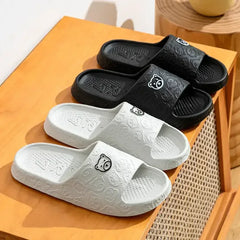 White and black slide sandals with bear logo and textured sole