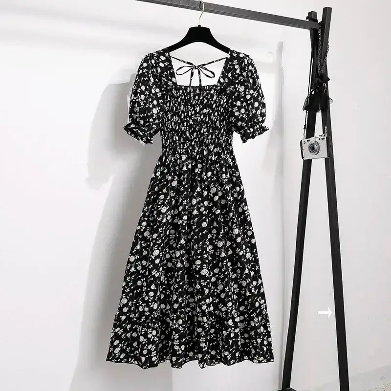 Black floral A-line dress with smocked bodice, short puff sleeves, and elastic waist