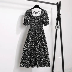 Black floral A-line dress with smocked bodice, short puff sleeves, and elastic waist