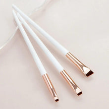 Angled makeup brush set with white handles, gold ferrules, and brown angled bristles