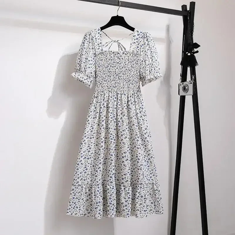 Blue ditsy floral A-line dress with smocked bodice, short puff sleeves, and elastic waist