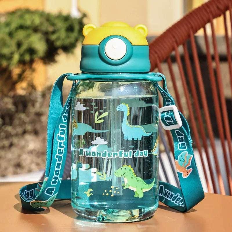 Teal kids sippy cup with straw and dinosaur print, supported by a carry strap.