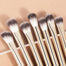 Makeup brush set with cream handles and white-and-gray bristles, angled arrangement