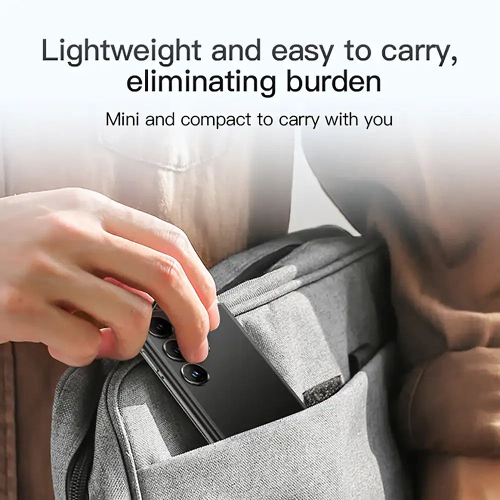 Hand placing compact black SOYES S24 Pro Max mini smartphone into backpack pocket showing lightweight portability