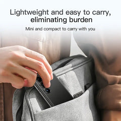 Hand placing compact black SOYES S24 Pro Max mini smartphone into backpack pocket showing lightweight portability