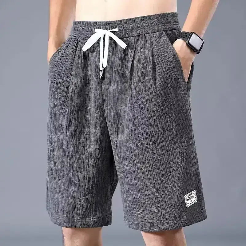 Men's gray drawstring shorts with loose straight fit and side patch logo
