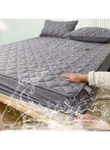 Dark grey waterproof fitted topper with quilted texture, water beading on surface