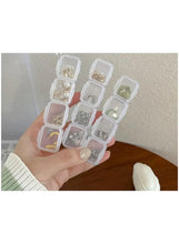 Transparent plastic organizer box with small square compartments, held in a hand