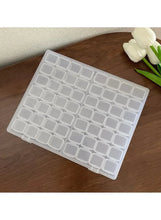 Transparent plastic storage case with grid compartments on a wooden surface