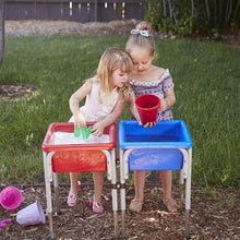 Children playing with blue and red water play table on outdoor grass
