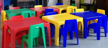 Assorted colorful plastic kids chairs in red, green, yellow, and blue