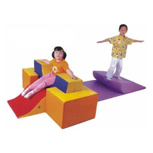 Indoor foam obstacle course with curved padded blocks, steps, and slide ramps
