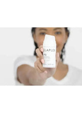 Olaplex No. 8 moisture mask held up in front of a woman’s face