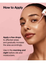 Woman applying red face serum from a dropper to her cheek