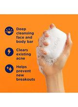 White benzoyl peroxide cleansing bar with foamy lather on hands