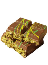 Chocolate bar pieces with pistachio crumble and drizzle, dark brown