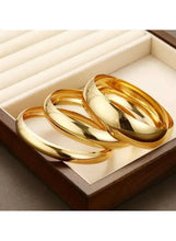 Gold tone bangle bracelet set in wooden box, three stacked shiny bangles