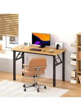 Adjustable laptop table with light wood top, black support frame, desk items