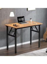 Adjustable laptop table with light wood top and black legs, devices and cup
