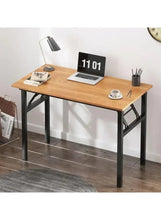 Adjustable laptop table with light wood top and black metal legs, laptop on top
