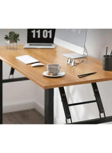 Adjustable laptop table with light wood top and black legs, laptop and mug