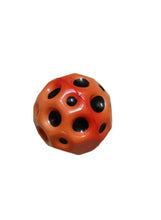 Orange rubber bounce ball with black round cutouts