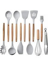 Gray silicone cooking tools with wooden handles arranged for a set view