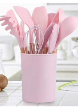Pink silicone cooking utensil set standing in a pink canister with utensils inside.