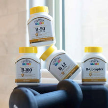 B-100 Complex supplement bottle among other vitamin bottles with yellow caps