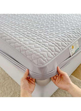 Light grey fitted waterproof mattress topper, close-up of stitched edge