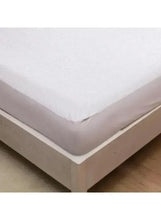 White plush fitted bed sheet corner with elastic seam and tucked edge