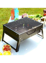 Outdoor folding BBQ grill with metal grate, side handles, and food on the grill